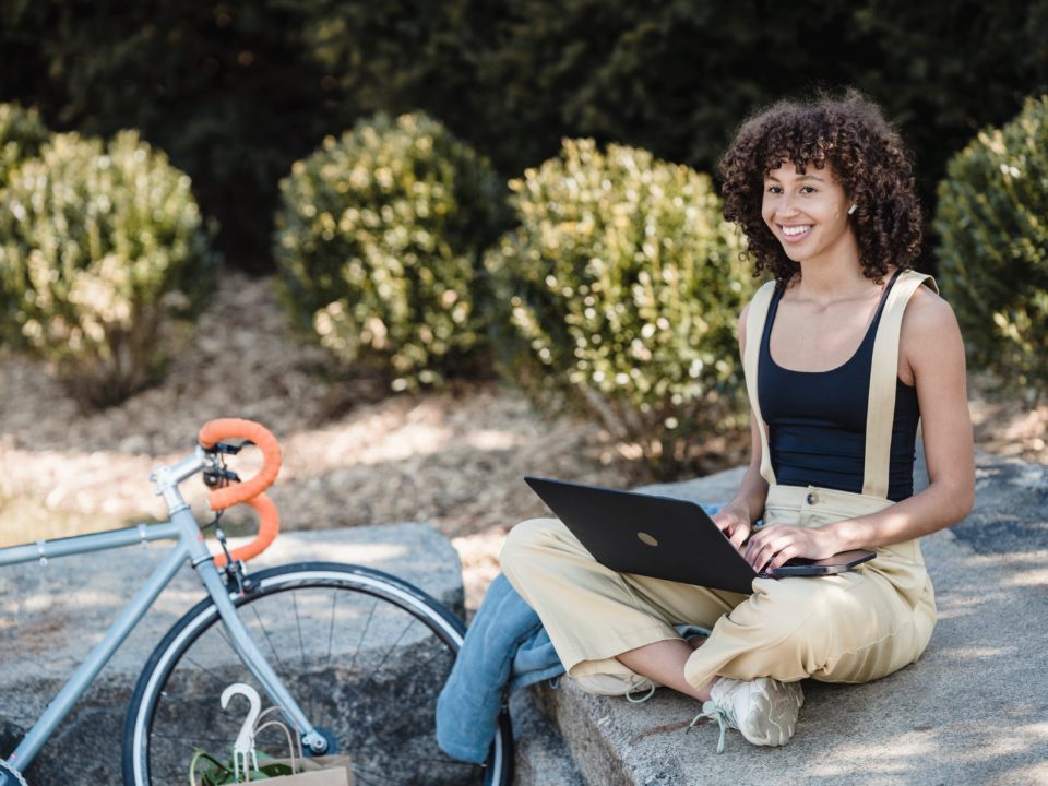 cheerful female using laptop outdoors